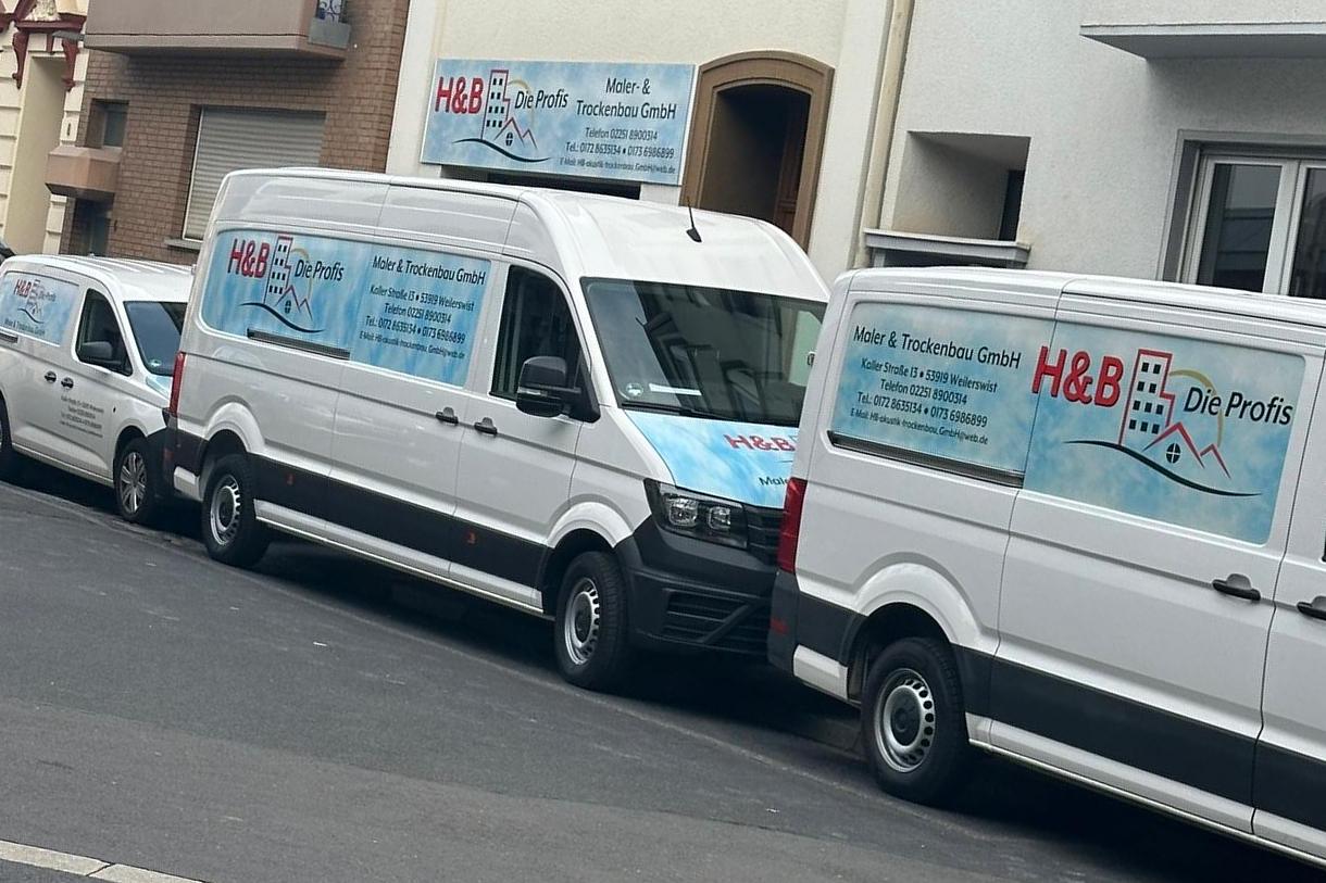 Transporter von H&B Die Profis in einer Straße, am Haus dahinter das Firmenschild