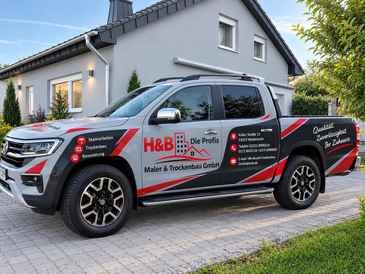 Grauer Pick-up mit H&B-Beschriftung vor einem Einfamilienhaus